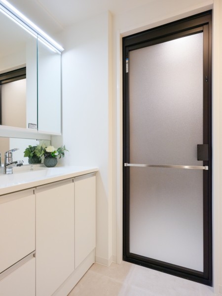 ホワイト基調のスタイリッシュな洗面化粧台。明るく照らされた三面鏡付きのため、ヘアセット等の身だしなみを整える時間も快適にお使いいただけます。