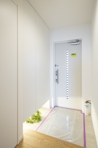 清潔感のある玄関は、フットライトからのびる光が足元を優しく包み込みます。天井までの高さがあるシューズボックスを備え付けたので、玄関をすっきり綺麗に保てます。