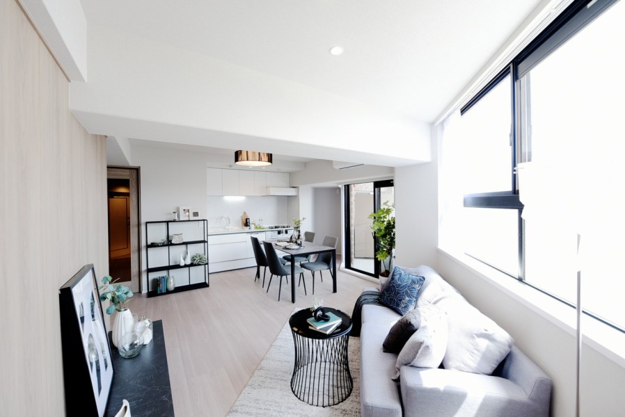 10階部分の南東角住戸、特徴ある形をしたLDKは、２面採光で陽当たり・通風良好です。シンプルな色味でまとめられた内装はどんな家具とも相性が良く、お好みの空間を演出できます。