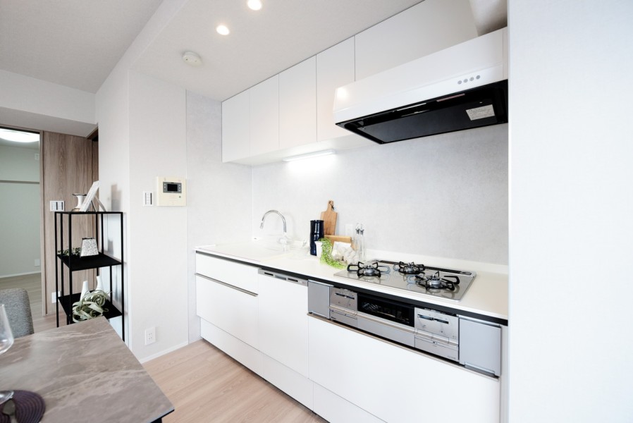 ホワイトの清潔感溢れるシステムキッチンです。吊戸棚を設置していますので、調理器具や調理家電をたっぷりと収納出来ます。食器洗浄乾燥機完備で、家事の時短に役立ちます。