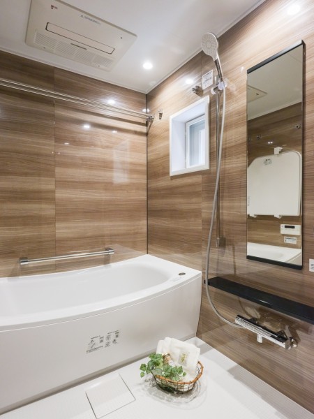 浴室には窓があるので、自然光を採り込み換気にも嬉しいバスルームです。光沢のある木目調のパネルが、より一層くつろぎの空間へ誘います