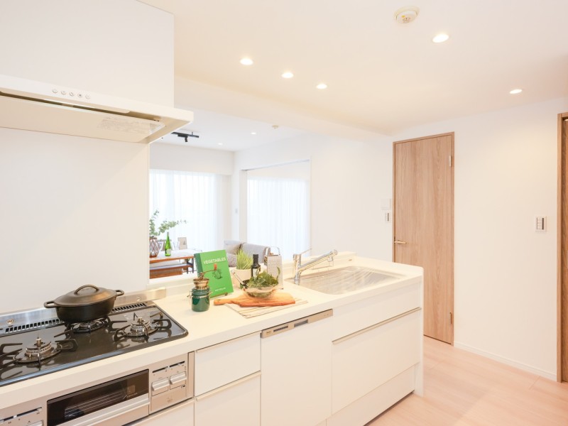 ホワイト基調のお部屋に溶け込む、まるでインテリアの一部のようなカウンターシステムキッチンです。家事時短に便利な食洗器を搭載し、デザイン性と機能性を兼ね備えた仕上がりです。