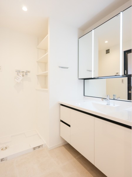 三面鏡付きのラグジュアリーな洗面化粧台です。カウンター部分にもゆとりがあり、身だしなみを整えるスペースも確保できます。リネン類を収納する可動棚があるため、ランドリーグッズもしっかりと保管できますね。