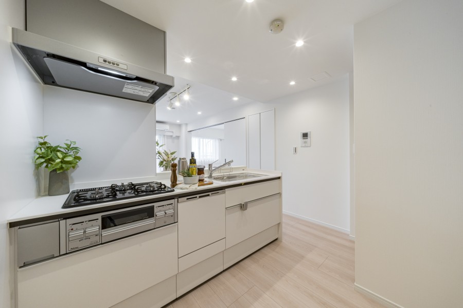 お部屋に溶け込むホワイトカラーのシステムキッチンです。スライド式収納は奥のものも見やすく収納でき、出し入れのしやすさが魅力です。