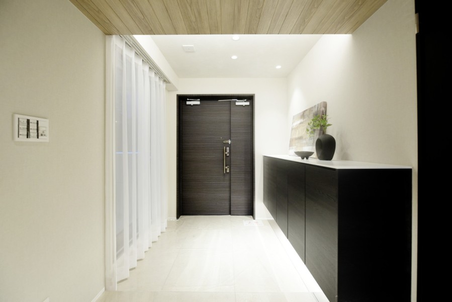 玄関はインナーバルコニー・吹抜けへの大きなガラスの開口部分が非常に印象的です。フットライトや間接照明が優しくゲストや家族を迎えます。大容量のシューズボックス完備で、スッキリとした空間を保てます。