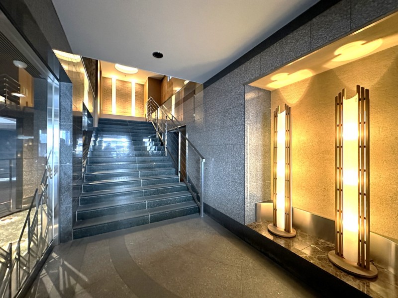 御影石を使用し、印象的な照明や内装にこだわりを感じるエントランスです。ご家族やゲストを優しく迎え入れるラグジュアリーな空間です。