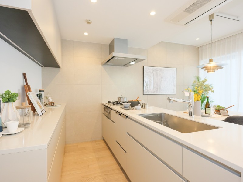 洗練されたお部屋に溶け込む田中工藝製のオリジナルキッチンです。家事時短に役立つ食器洗浄乾燥機を搭載し、背面には収納豊富なカップボードを備えています。