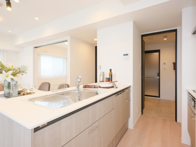 お部屋の雰囲気に溶け込む、インテリアの一部のようなオープンキッチンです。奥の扉は洗面室につながり、水まわりに関係する部屋を一直線に配置しました。