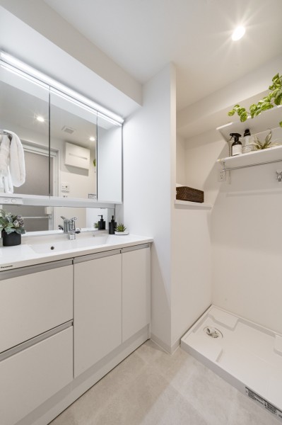 白を基調とした清潔感溢れるデザインの洗面化粧台です。洗濯機置き場の上には、洗剤やタオルなどの置場に便利なカウンター棚を備え付けています。