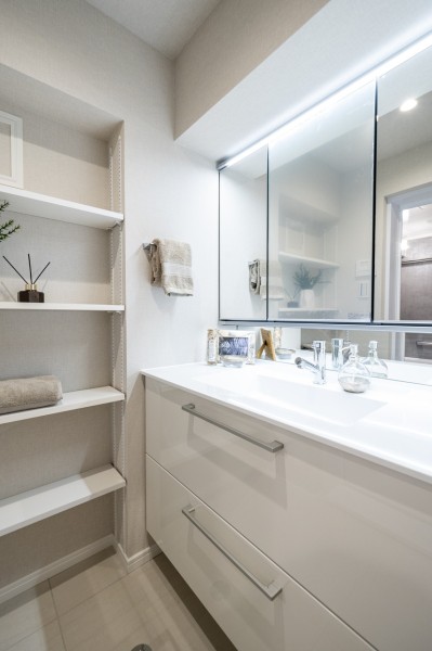 白を基調とした清潔感溢れるデザインの洗面化粧台です。収納棚を設置しましたので、お好みのインテリアを飾ったり、リネン類などの収納にもお使いいただけます。