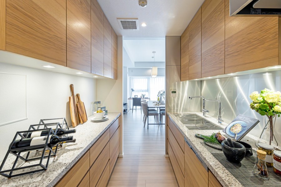 癒しの木目調の面材と石調の天板がモダンな空間を演出するキッチンスペースです。汚れを落としやすいガラストップのコンロやディスポーザー、浄水器付きです。