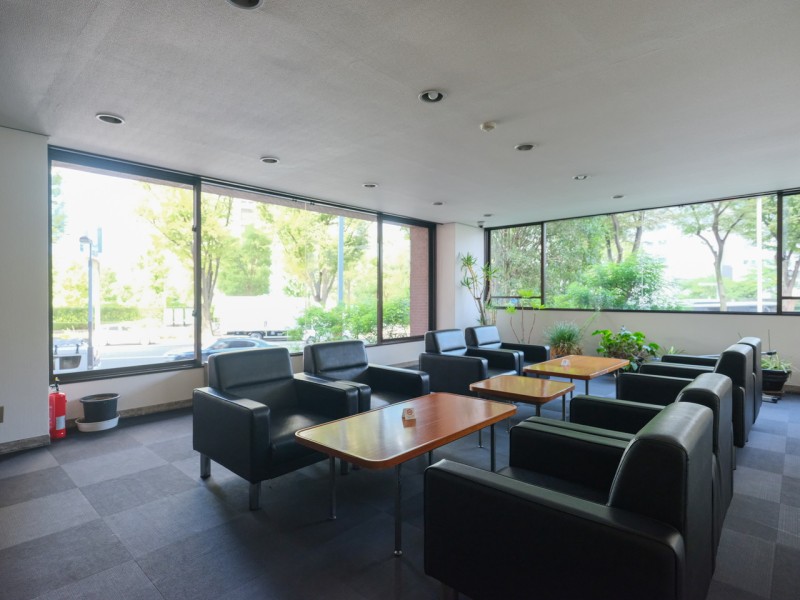 事務所利用可(規約有)なマンションです。二面の窓からたっぷりと明かりを取り込むロビーにはソファセットが配置されています。