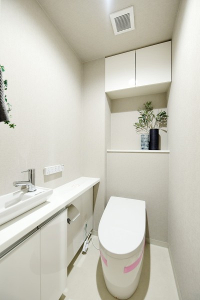 TOTO製ウォシュレット一体型のタンクレストイレ新規交換済みです。タンクが無いのですっきりとした空間です。吊戸棚がありますので、小物類や洗剤類の収納に便利です。