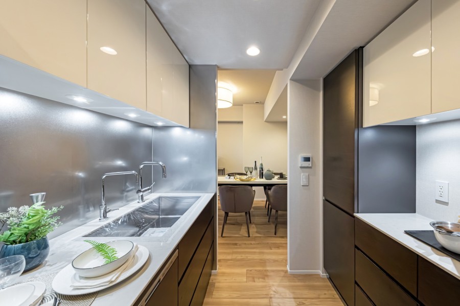 デザイン性と機能性を兼ね備えたシステムキッチンです。キッチン背面には収納豊富なカップボードと、ゆとりあるカウンタースペースがあります。