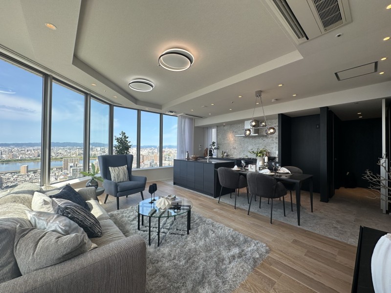 リビングのドアを開けた瞬間に一面の大きな窓から淀川や大阪の街並みを臨む眺望が広がります。開放感に包まれる、約22.4帖のLDKです。リビングと主寝室側で使用する建具の色を分けるなどこだわりの内装です。