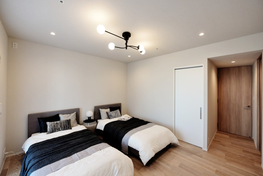 洋室1（約9.8帖）はバルコニーに面し、明るい光が入ります。ベッドを置いてもゆったり使用できます。リビングとは建具の色を分け、ゆったりとリラックスして過ごせる内装に仕上げています。ウォークインクローゼット設置しています。