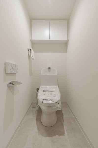 シンプルで安らぎが宿るレストルームです。大きな吊戸棚を設け、掃除用品やペーパー類のストックがすっきりと収納いただけます。