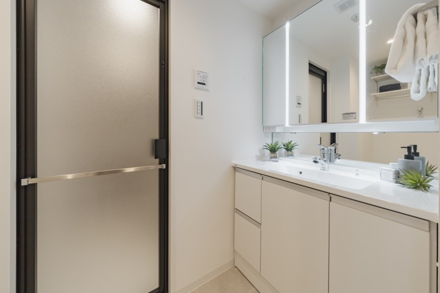 空間に美しく溶け込む飽きのこないシンプルなデザインの洗面化粧台です。三面鏡の裏側や足元のキャビネットなど、収納豊富で実用的な洗面空間です。