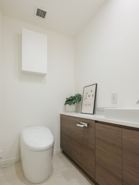 レストルームには洗練された住まいにふさわしい、スタイリッシュなタンクレストイレを新規設置しました。手洗い場や収納に便利な吊戸棚も備え付けです。