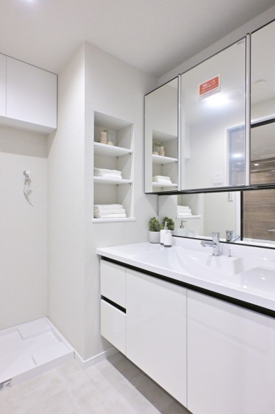 収納豊富な三面鏡タイプで使い勝手の良い洗面化粧台です。タオルや着替え、洗剤などの収納に便利な棚を備え付けました。