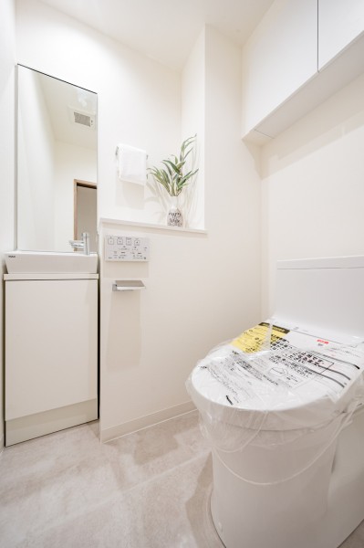 TOTO製洗浄便座付きトイレを設置しました。専用の手洗いボウルと大きなミラーも付いているので、身だしなみを整えるのにも便利です。