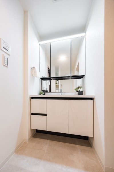 空間に美しく溶け込む飽きのこないシンプルなデザインの洗面化粧台です。三面鏡の裏側や足元のキャビネットなど、収納豊富で実用的な洗面空間です。