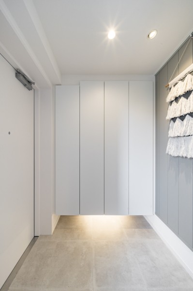 フットライトからのびる光が足元を優しく包み込む玄関です。人感センサー付きライトを設置したので、暗い時間帯のご帰宅や両手が塞がっているときも快適です。