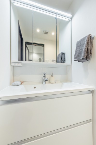 空間に美しく溶け込むスタイリッシュなデザインの洗面化粧台です。三面鏡の裏側や足元のキャビネットなど、収納豊富で実用的な洗面空間です。
