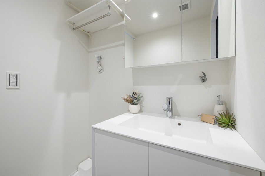 身支度の時間をも快適に彩る、美しく空間に溶け込む洗面化粧台です。洗濯機置場の上には可動式で便利な棚を備え付けました。