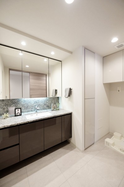 大きな三面鏡で身だしなみも整えやすい洗面です。三面鏡裏は収納ですので、小物類が増えがちな洗面廻りもすっきりと整頓出来ます。天然石貼りの高級感あふれるカウンターです。