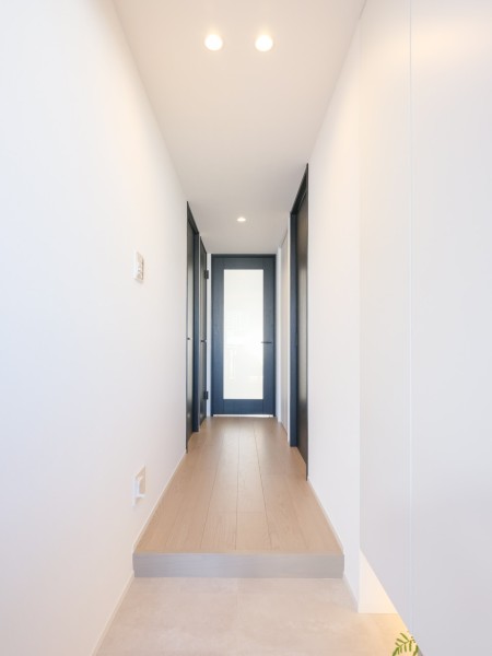 フットライトからのびる光が足元を優しく包み込む玄関です。人感センサー付きライトを設置したので、暗い時間帯のご帰宅や両手が塞がっているときも快適です。