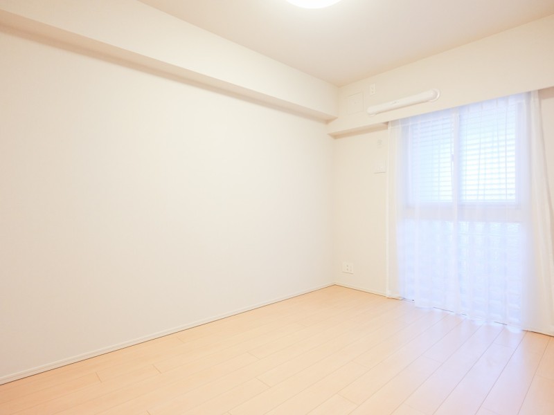 穏やかな自然光が注がれる洋室1です。ウォークインクローゼットが設けられているため、荷物はたっぷりしまい居室部分は広々とお使いいただけます。