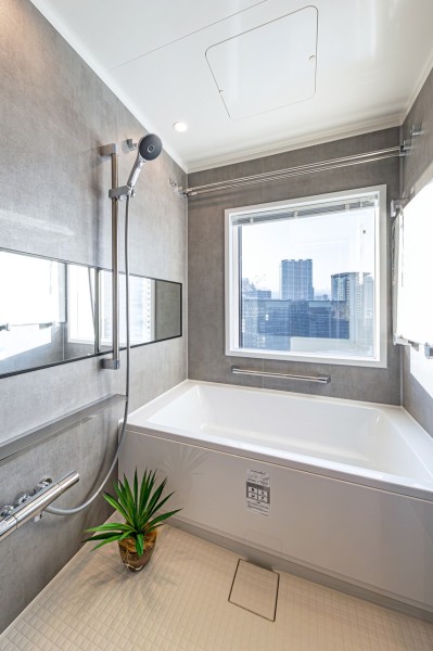 LIXIL製ユニットバスを新規設置。窓が付いているので自然な明かりを取り込むことができ、明るく開放的な空間です。横長のミラーは洗い場でもバスタブ内でも使え便利なうえ、浴室を広く見せる効果もあります。