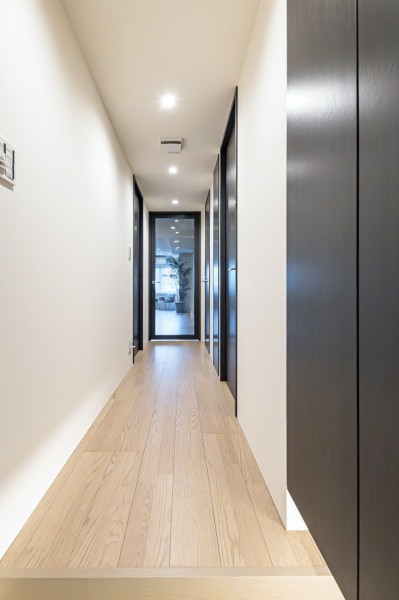 玄関からリビングダイニングキッチンへ続く廊下です。リビングからの明るい光も採りこみ、いつでもほっとする空間です。フットライト付のシューズボックスも備え付けています。