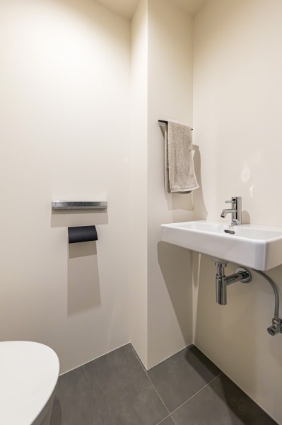 TOTO製ウォシュレット一体型のタンクレストイレを採用しました。タンクが無いのですっきりとした空間です。手洗いカウンターを設置し、家族やゲストが気兼ねなく使用していただけます。