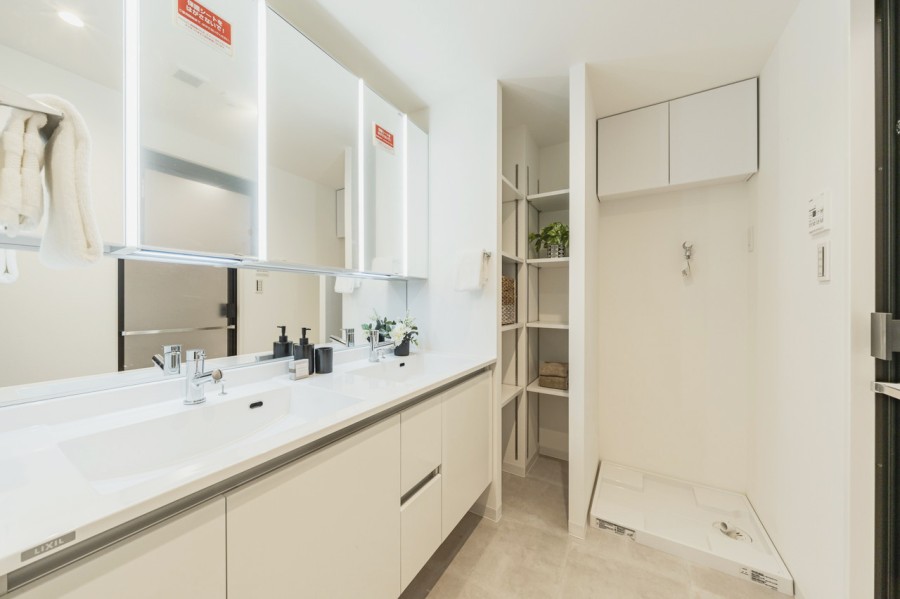 ダブルボウルの大きな洗面台は大きな鏡で身だしなみも整えやすく、朝の慌ただしい時間帯も快適です。頼もしい収納棚を備え付けたので、細々としたものが多くなる洗面室もすっきり保てそうです。