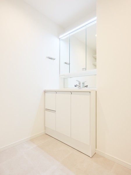 空間に美しく溶け込む白を基調とした明るいデザインの洗面化粧台です。三面鏡裏や足元の収納など使いやすさも兼ね備えています。