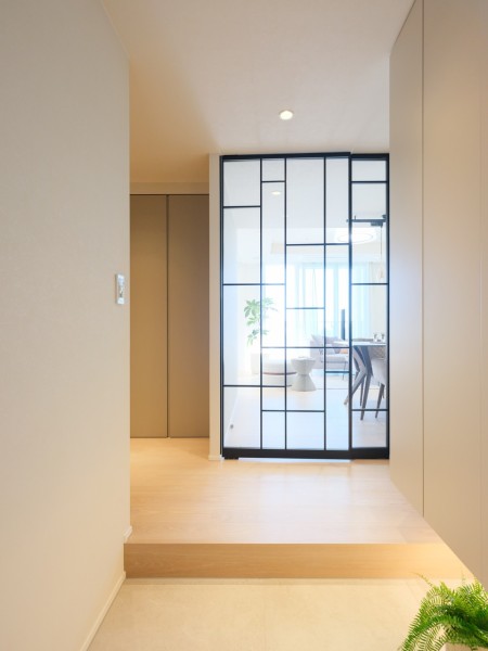 ダイニングからの光が優しく包み込む気品溢れる玄関です。天井までの高さがあるシューズボックスを備え付けたので、玄関をすっきり綺麗に保てます。