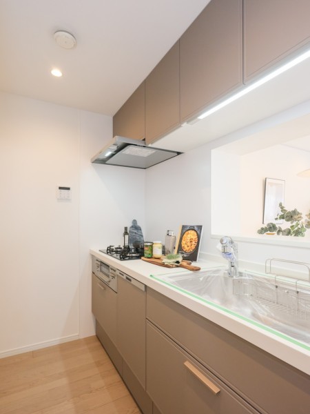 ガラストップを採用した美しく、お手入れのしやすいキッチンです。カフェブラウンの面材がお部屋にアクセントをもたらし、インテリアの一部のように溶け込みます。