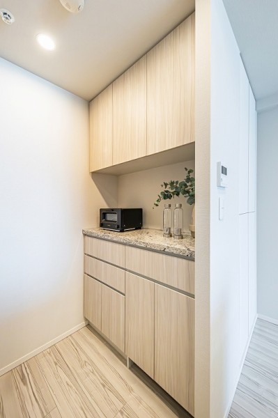 背面にはキッチンとお揃いでスタイリッシュなカップボードがあり、活躍しそうなスペースです。快適な家事動線が確保されたオープンキッチンです。