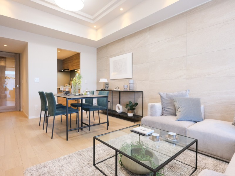 約16.9帖のゆとりあるLDKです。壁の重厚感のあるタイルが上質と上品さをさりげなく漂わせるリビングです。