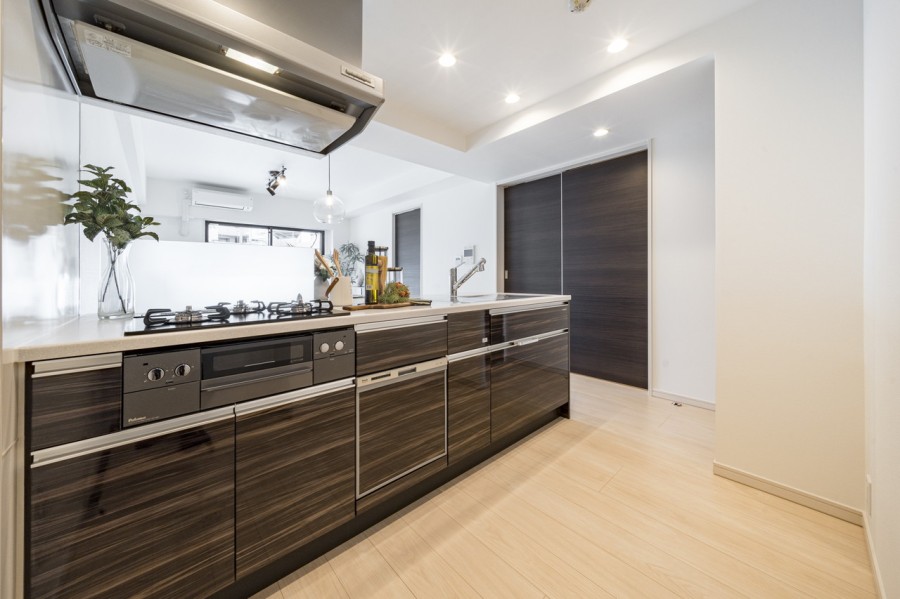 対面式のオープンキッチンで、家族とのコミュニケーションを大切にしながら家事ができます。三口コンロや浄水器、そして食器洗い機が搭載されたシステムキッチンです。