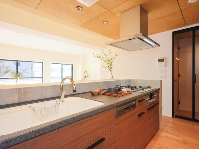 システムキッチンは重厚感漂うハイグラーナブラックのカウンターを採用。扉のミディアムチークカラーが美しく、より洗練されたラグジュアリーな空間へと演出します。