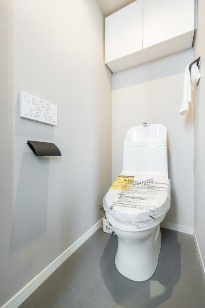 レストルームも上品さが宿る安らぎのスペースに仕上がりました。トイレットペーパーなどの収納に便利な吊戸棚を備え付けました。