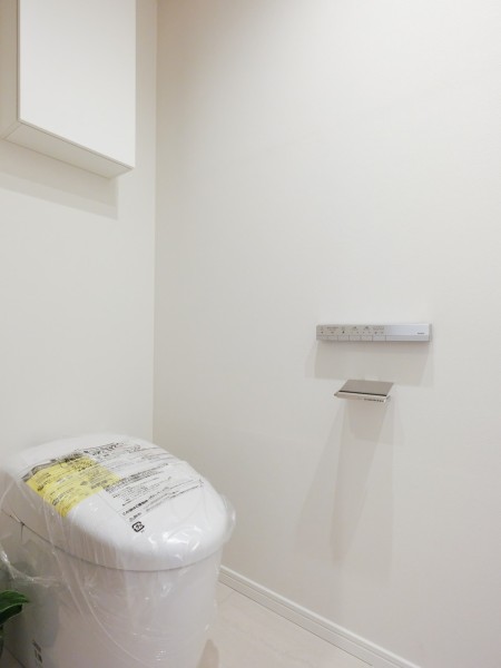 レストルームにはスマートなスティックリモコンや、すっきりとしたタンクレストイレを設置しています。上部吊戸棚収納もあり、ペーパー類や掃除用品をしっかりと収納いただけます。