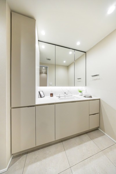 空間に美しく溶け込む、田中工藝製のスタイリッシュなデザインの洗面化粧台です。置場に困るタオルや着替え、ストック用品などを収納できるリネン棚を造作しました。