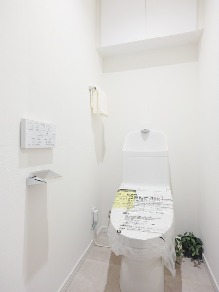 ホワイト基調のシンプルで安らぎが宿るレストルームです。トイレットペーパーなどの収納に便利な吊戸棚を備え付けました。