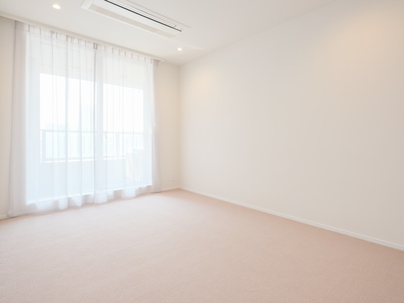 天井までの高さがある窓から光が差し込む洋室1です。柔らかな光と爽やかな風を感じることができるのびやかなお部屋です。