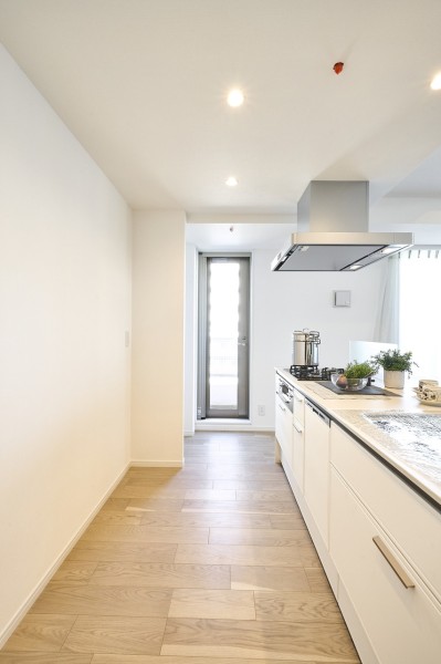 キッチン奥の勝手口は、お部屋の換気やお料理の途中にホッと一息入れるなど様々な用途にお使いいただけます。扉からの光を取り込む明るいキッチンです。