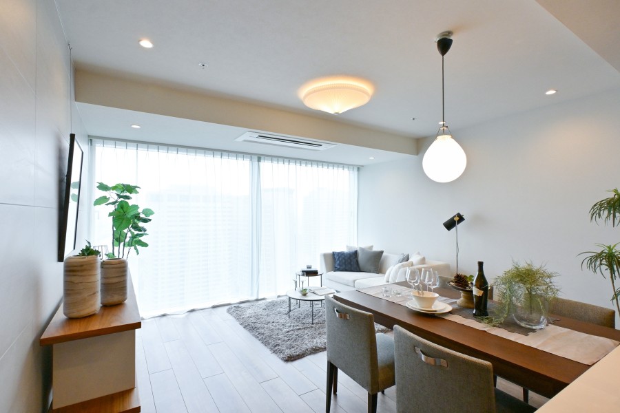 壁一面が窓という「パノラマウィンドウ」のもたらす開放感と柔らかな自然光が享受できる住まい。床材には落ち着きのあるトリニティのバーチグレーを採用しました。穏やかな時間と上質感を味わえるお部屋です。